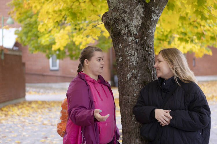 kaksi naista syksynkeltaisen puun alla