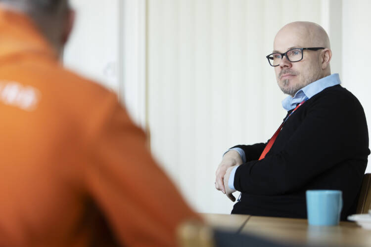 kaksi miestä vastatusten pöydän ääressä