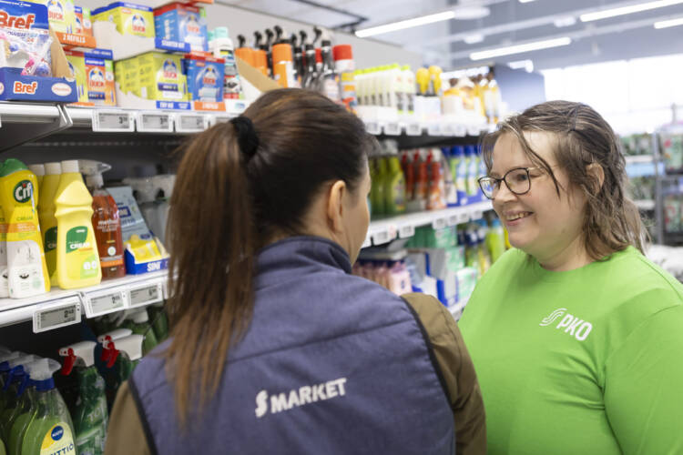 nainen juttelee työkaverin kanssa